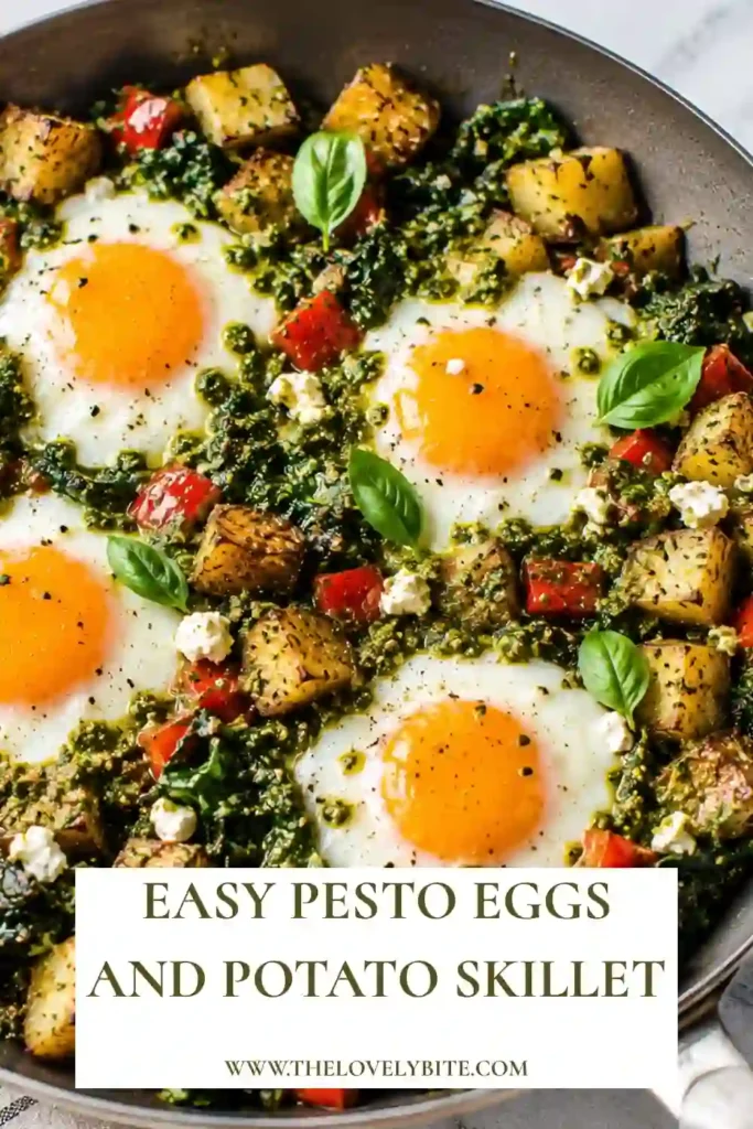 Freshly cooked Pesto Eggs and Potato Skillet topped with crumbled feta cheese and basil pesto. The colorful vegetables and eggs create an inviting breakfast perfect for any morning.