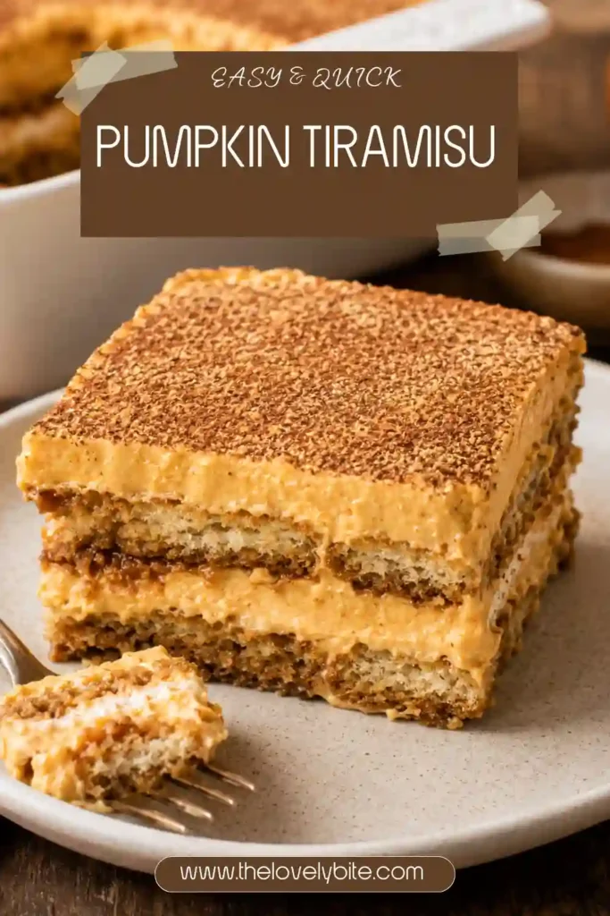 A slice of pumpkin spice tiramisu showing layers of ladyfingers and thick pumpkin mascarpone cream. Dutch-process cocoa covers the top for a rich chocolate finish.