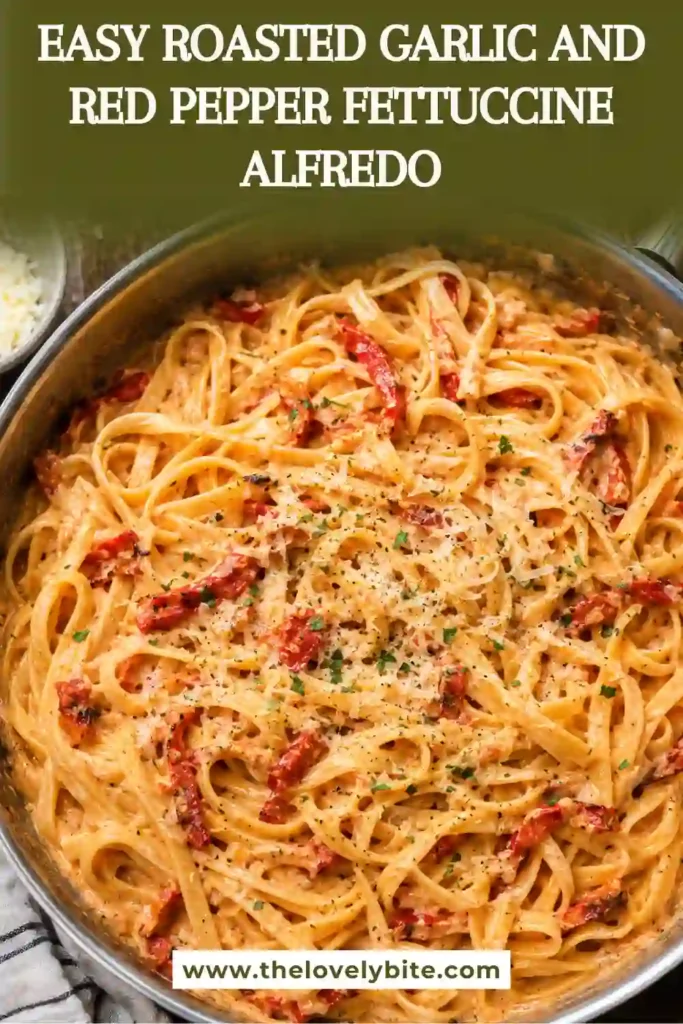 A bowl of Roasted Garlic and Red Pepper Fettuccine Alfredo with creamy red pepper sauce coating long strands of fettuccine. Fresh parsley and grated Parmesan finish the colorful pasta dish.