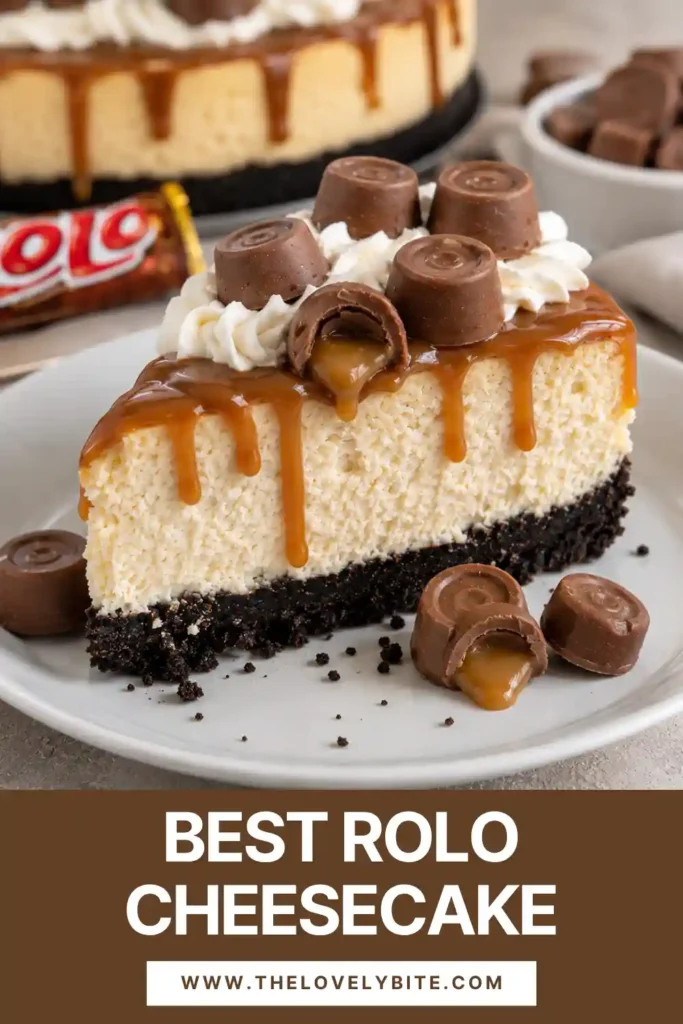 Whole Rolo Cheesecake topped with glossy caramel sauce, whipped cream swirls, and caramel chocolate candies. The cheesecake has a dark chocolate cookie crust and creamy center.