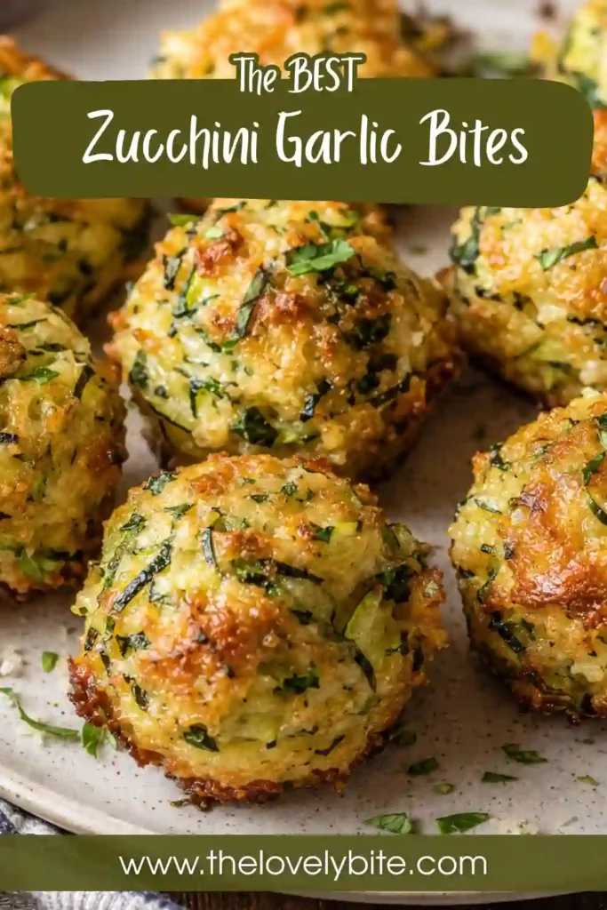 Cheesy zucchini bites arranged on a serving plate with fresh parsley and marinara dipping sauce. The baked bites have golden exteriors with visible pieces of zucchini and herbs.