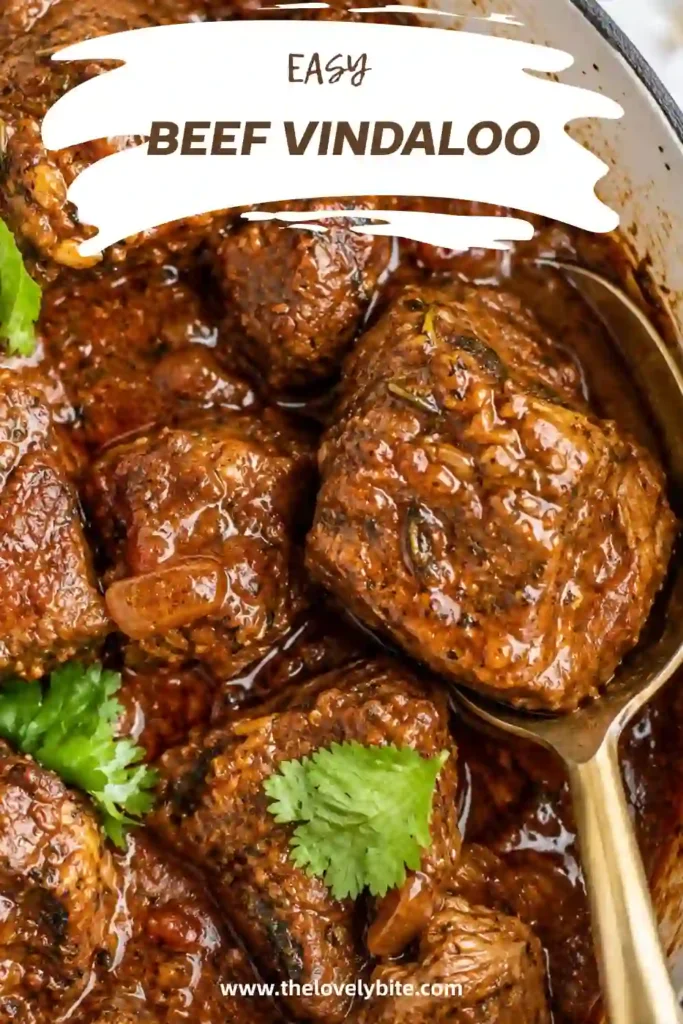 A comforting bowl of Beef Vindaloo with tender beef, caramelized onions, and aromatic Indian-inspired spices. The curry is paired with basmati rice, naan, and creamy Greek yogurt.