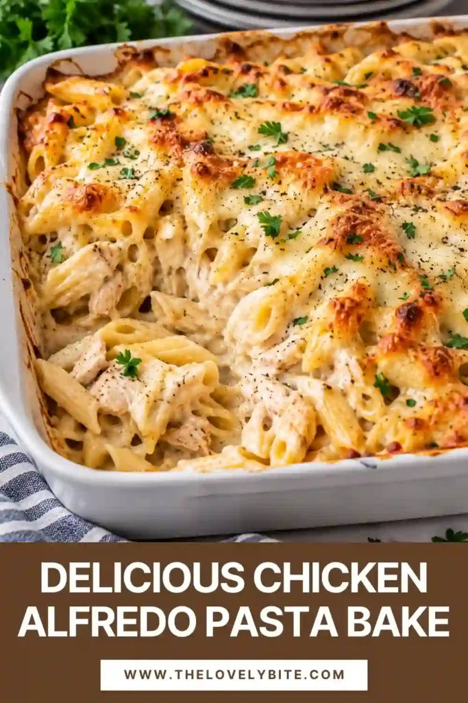 A generous serving of cheesy chicken pasta bake on a white dinner plate with creamy fusilli, shredded chicken, and mushrooms. The pasta is covered in Parmesan Alfredo sauce and topped with golden melted cheese and fresh parsley.