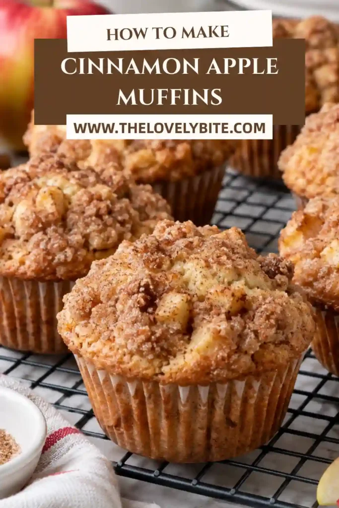 Fresh cinnamon apple muffins served on a breakfast plate with a warm drink and sliced apples. The fluffy homemade muffins have golden tops coated in buttery cinnamon sugar.