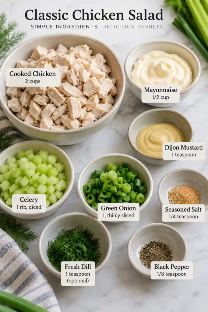 A close-up of homemade classic chicken salad showing tender shredded chicken, creamy dressing, celery, green onion, and fresh dill. This chicken salad recipe has a rich, smooth texture with crunchy vegetables throughout.