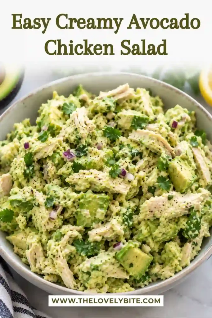 A creamy avocado chicken salad sandwich served on golden toasted bread with visible avocado chunks and shredded chicken. Fresh herbs and a rich avocado dressing create a delicious and satisfying lunch.