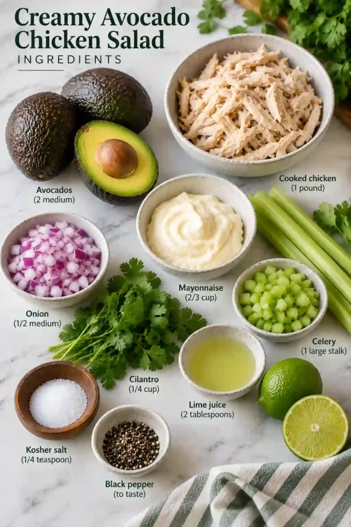 A bowl of Creamy Avocado Chicken Salad filled with tender shredded chicken, diced avocado, celery, and fresh cilantro. The creamy avocado dressing coats every bite, with lime wedges served alongside.