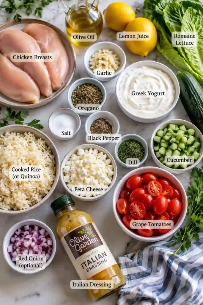A colorful Greek chicken bowl filled with sliced lemon-garlic chicken, fluffy rice, romaine lettuce, tomatoes, cucumber, and crumbled feta. Creamy homemade tzatziki sauce adds a refreshing finishing touch to this Mediterranean-inspired meal.