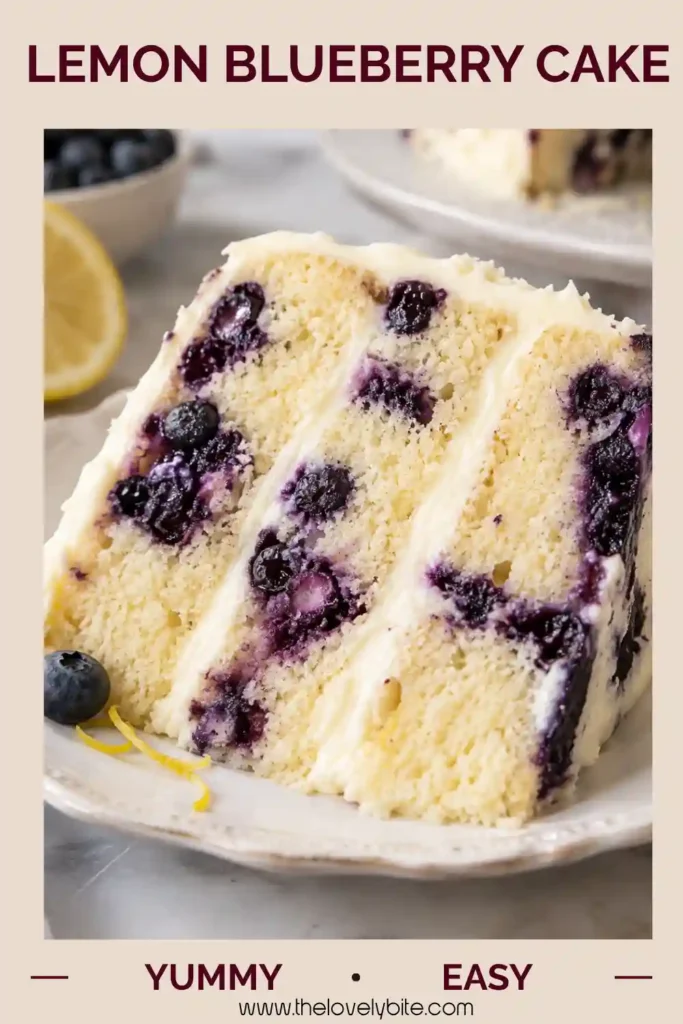 Homemade Lemon Blueberry Cake decorated with blueberries and lemon slices on top of smooth cream cheese frosting. The moist cake has a bright lemon flavor and colorful berry-filled interior.