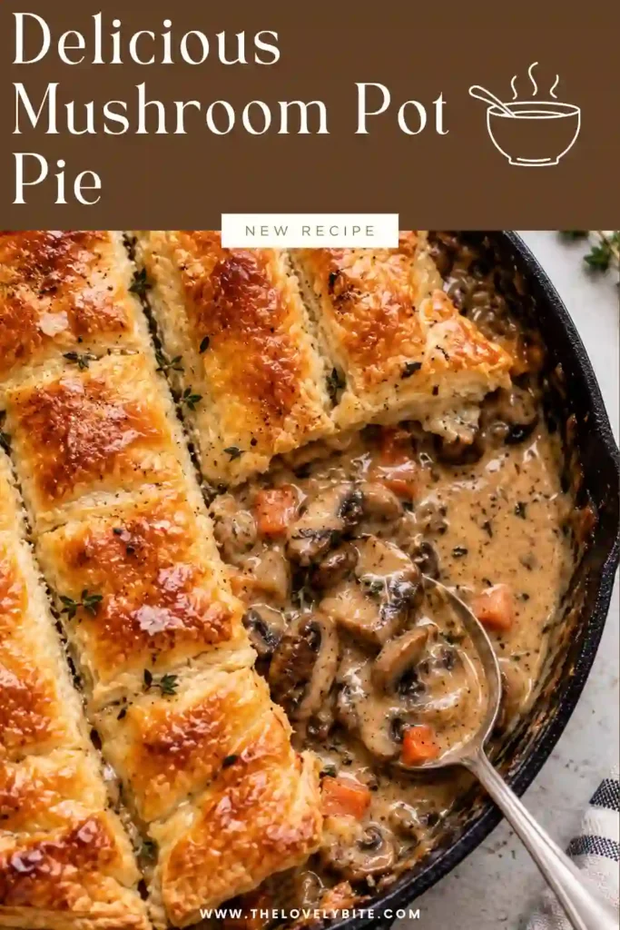 Freshly baked vegetarian pot pie topped with crisp, golden puff pastry. The creamy mushroom filling is visible around the edges of the flaky crust and looks rich and savory.