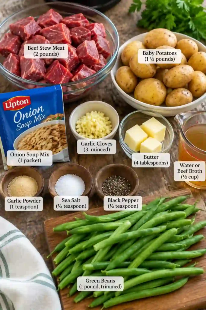 Slow Cooker Garlic Butter Beef Bites and Potatoes arranged in a serving bowl with colorful green beans. Tender beef and creamy potatoes are coated with flavorful garlic butter juices.