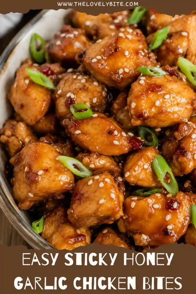 Sticky chicken bites served over fluffy white rice with green onions and sesame seeds. The juicy chicken is covered in a glossy garlic and honey sauce.