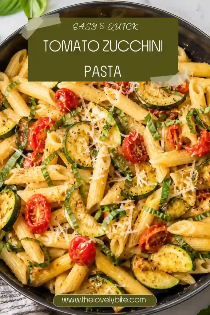 A close-up of tomato zucchini pasta featuring colorful cherry tomatoes, sautéed zucchini, garlic, Parmesan cheese, and fresh basil. The pasta is a simple vegetarian meal with fresh summer flavors.