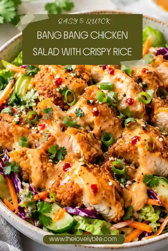 Bang Bang Chicken Salad served in a bowl with crispy rice, shredded chicken, cucumber, carrots, and fresh cilantro. Pickled red onions and creamy sriracha dressing complete the dish.