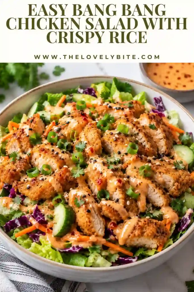 Colorful spicy chicken salad featuring crispy rice, fresh greens, shredded chicken, cucumber, carrots, and pickled onion. A creamy homemade bang bang dressing is drizzled over the top.